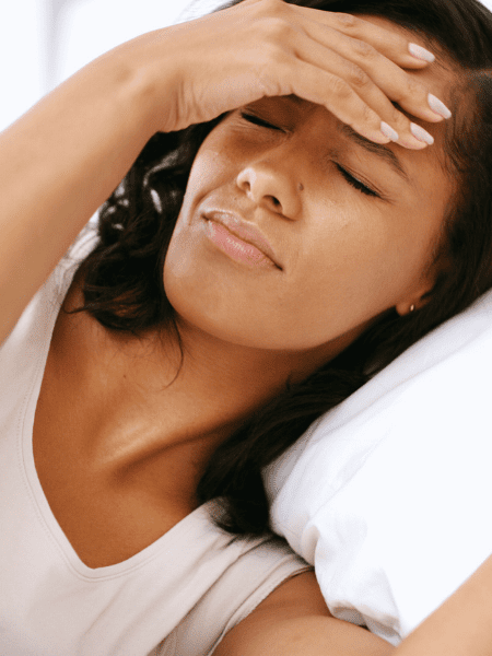 woman with hangover covers eyes