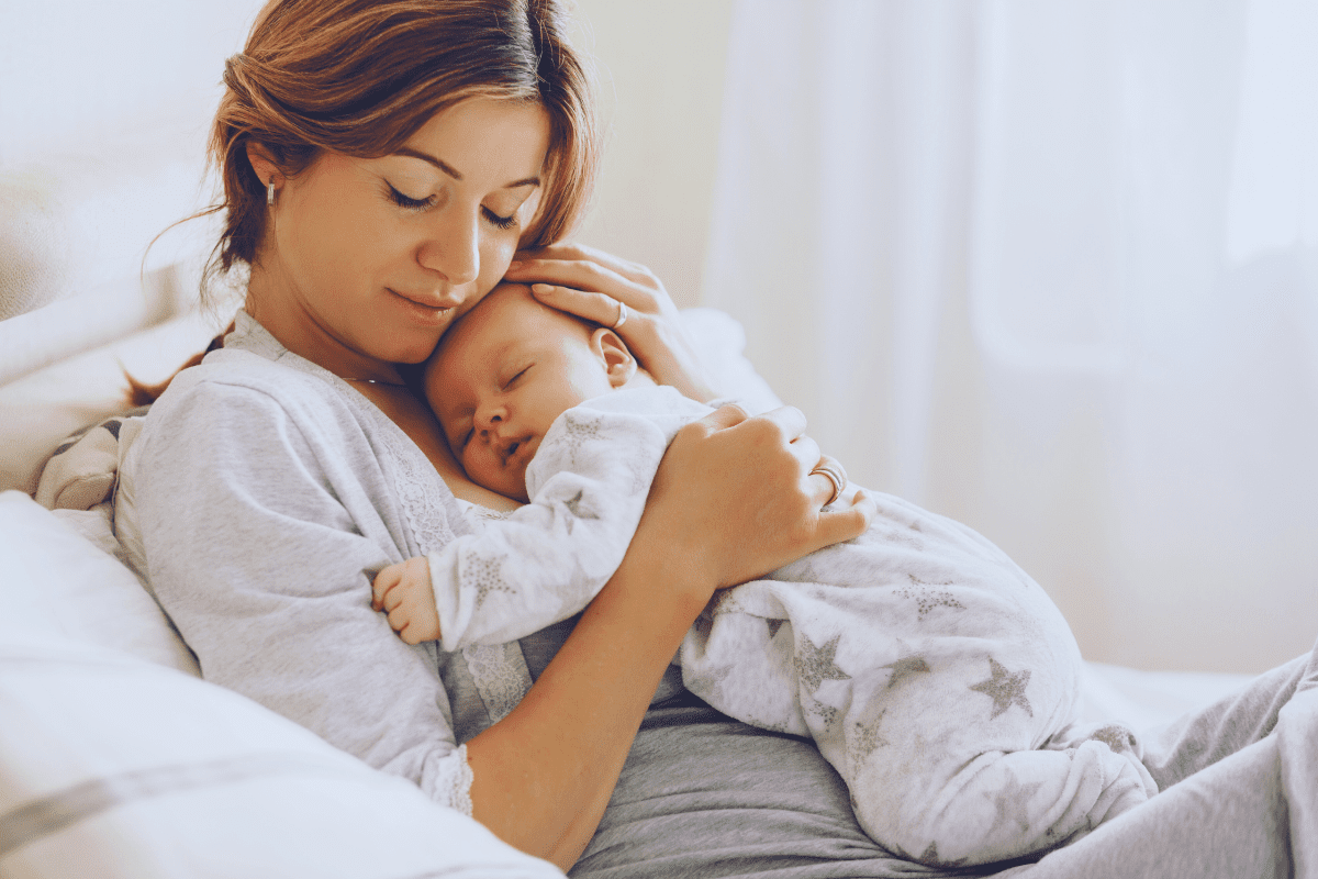 new mom snuggles baby while dealing with postpartum OCD